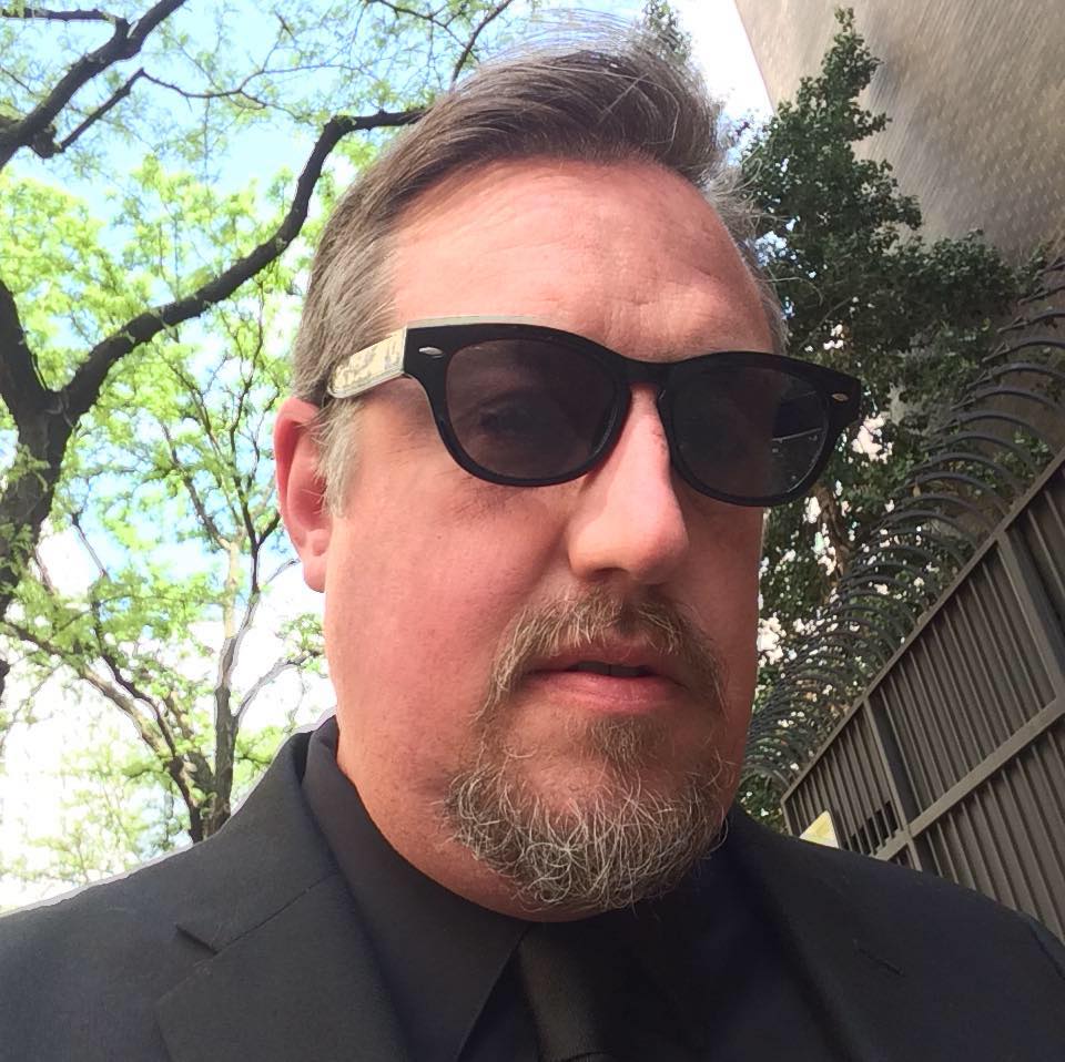 Ron Callahan in blacl suit and sunglases